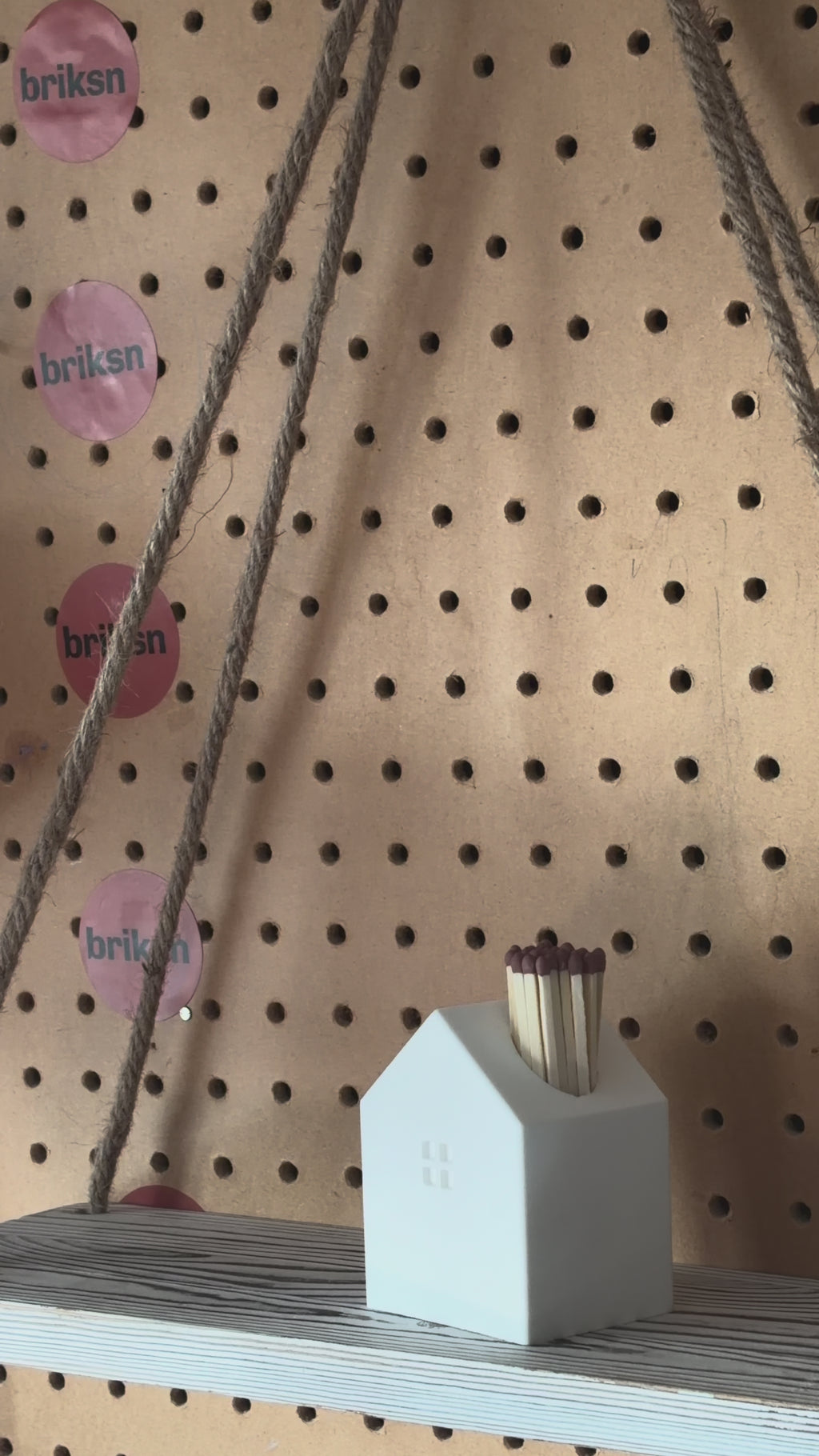 Lights match from a house shaped match holder